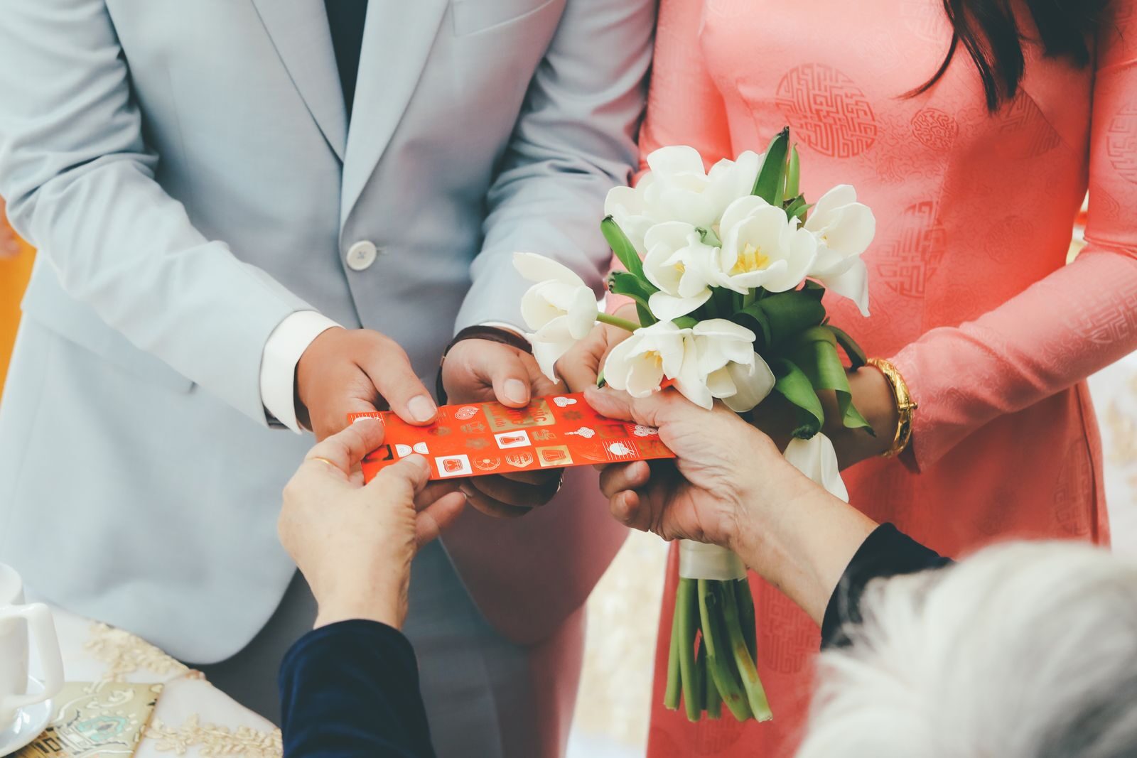 Close-up of a wedding gift exchange with a bouquet, symbolizing love and togetherness.